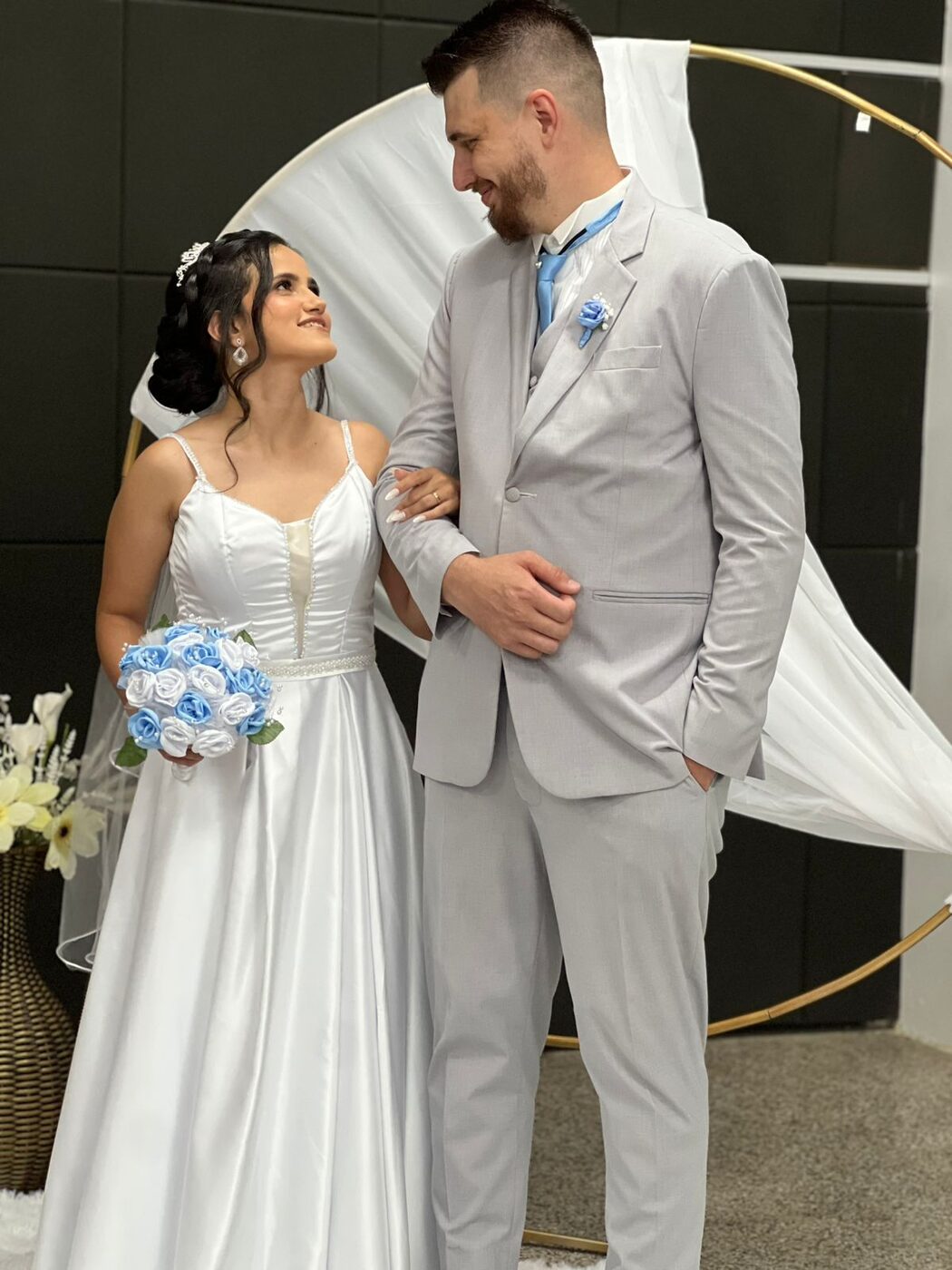 Casal de noivos com traje claro e vestido de noiva
